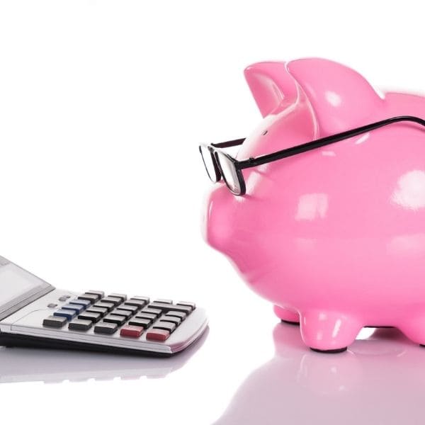 Tranquil-Admin-assistante-administrative-independante-lille-les-5-erreurs-qui-coutent-cher tirelire cochon rose qui regarde une calculatrice